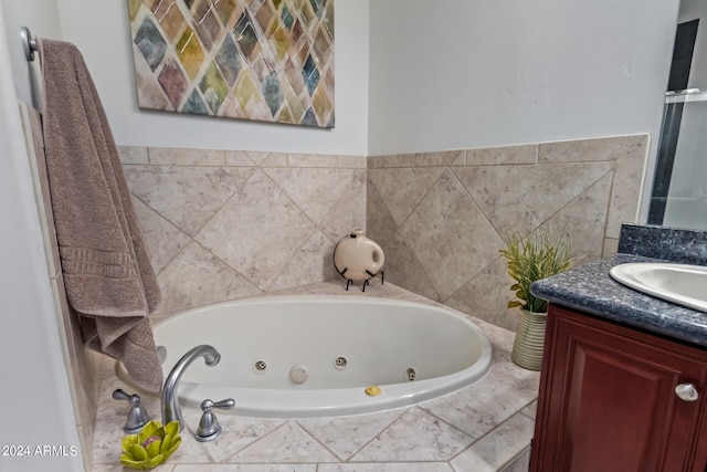 bathroom featuring vanity and tiled bath