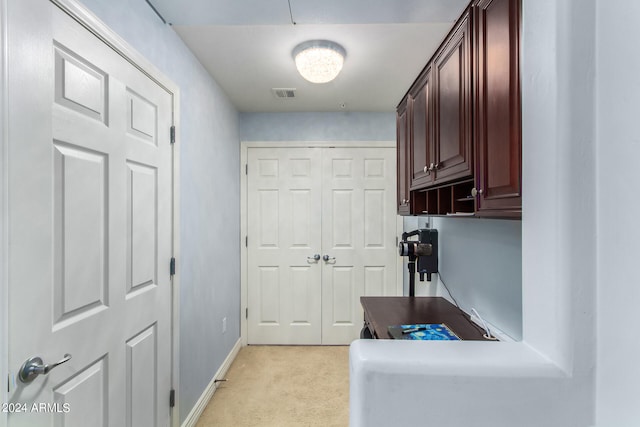 laundry area featuring light carpet