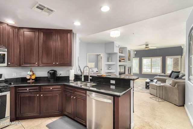 kitchen with light tile patterned flooring, built in features, sink, kitchen peninsula, and stainless steel appliances