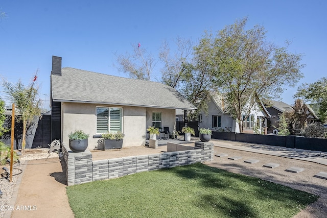 back of house with roof with shingles, fence, a chimney, and stucco siding