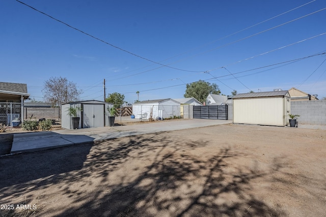 view of yard with fence, a storage unit, and an outbuilding