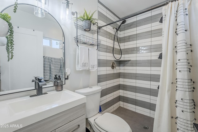 full bathroom with a stall shower, vanity, and toilet