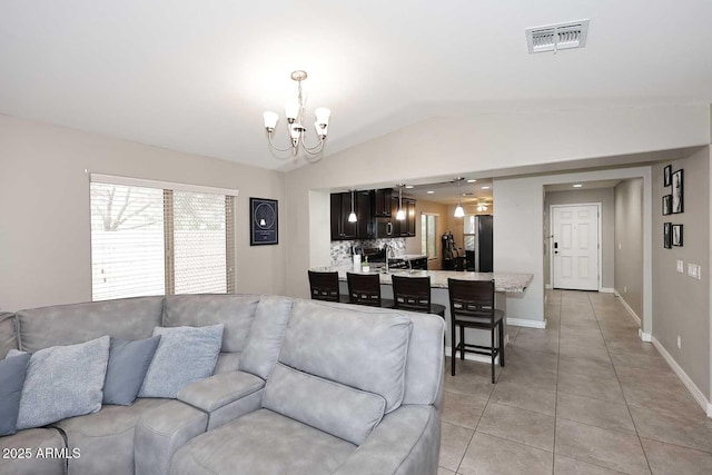 2005 E Anderson Dr E, Phoenix, AZ 85022 - living room featuring a chandelier, lofted ceiling, light tile patterned floors, and baseboards