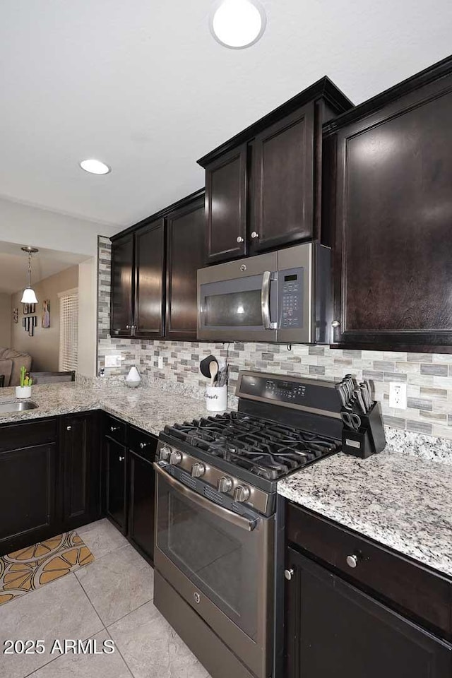 2005 E Anderson Dr E, Phoenix, AZ 85022 - kitchen featuring appliances with stainless steel finishes, decorative backsplash, light stone counters, and light tile patterned flooring