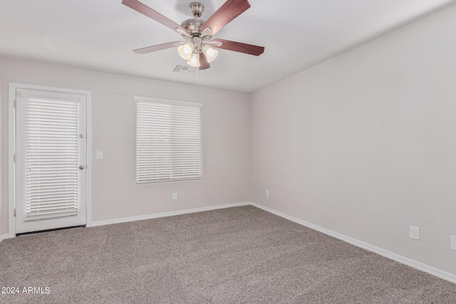 unfurnished room featuring plenty of natural light, ceiling fan, and carpet