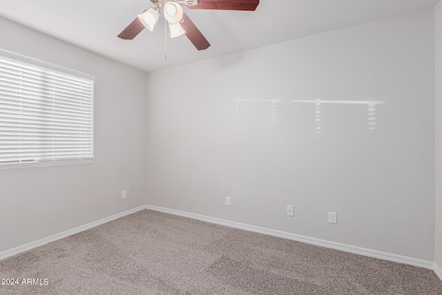 carpeted spare room featuring ceiling fan