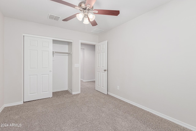 unfurnished bedroom featuring light carpet, ceiling fan, and a closet