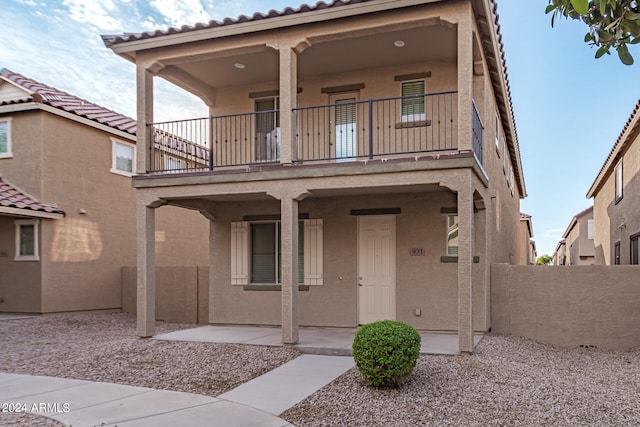 view of front of property featuring a balcony and a patio area