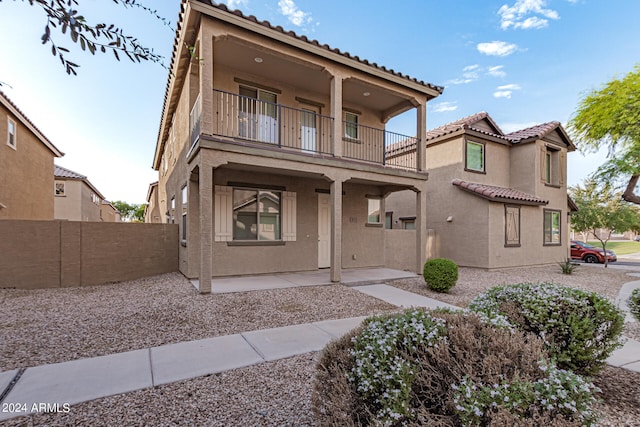 view of front of property with a balcony and a patio