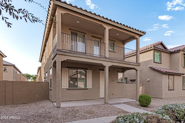 view of front of house featuring a balcony and a patio area