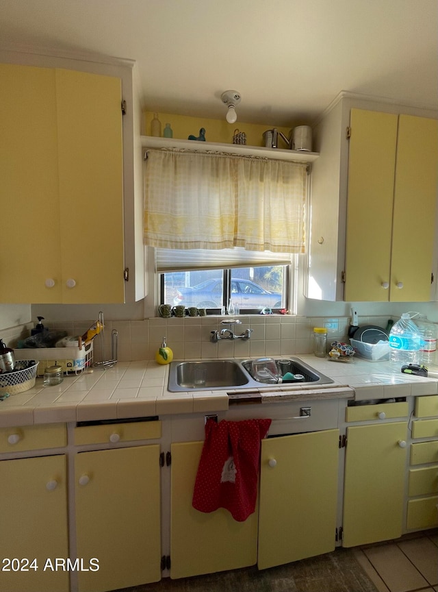 kitchen with decorative backsplash, sink, and tile counters