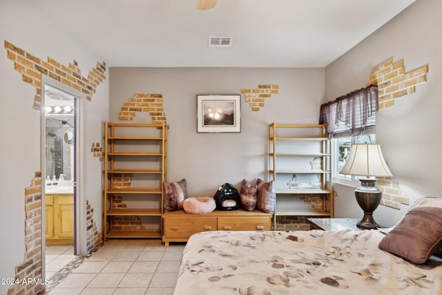 bedroom featuring brick wall, visible vents, ensuite bathroom, and tile patterned floors