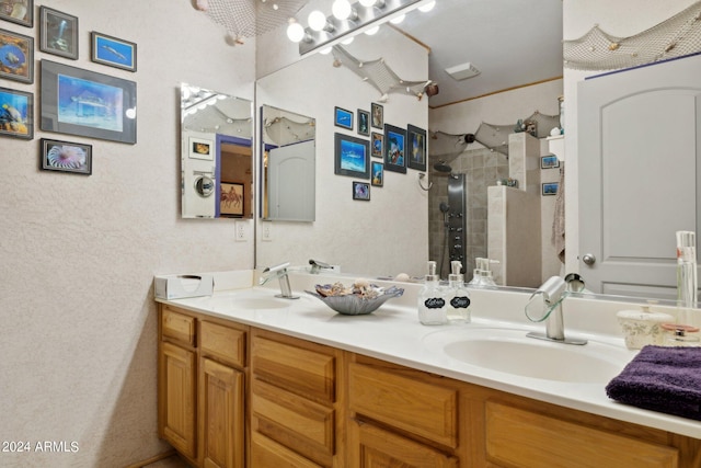 bathroom featuring tiled shower, a sink, and double vanity