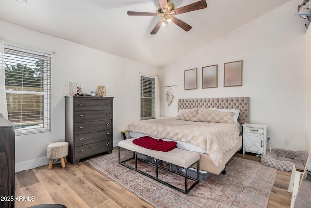 bedroom with baseboards, light wood finished floors, a ceiling fan, and vaulted ceiling