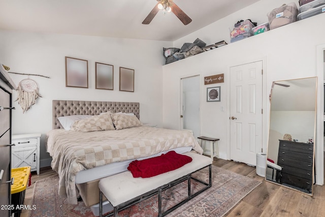 bedroom with wood finished floors and vaulted ceiling