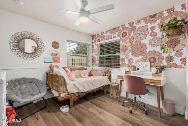 bedroom featuring a ceiling fan, wallpapered walls, and wood finished floors