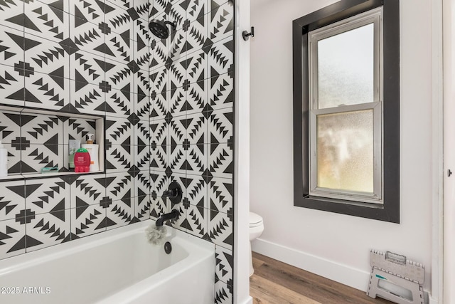 full bath with toilet, a tub to relax in, baseboards, and wood finished floors
