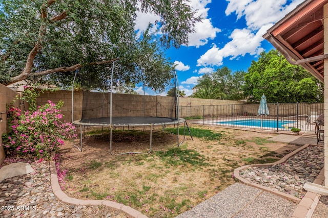 view of yard featuring a trampoline, a fenced in pool, and a fenced backyard
