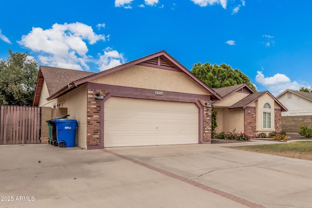 ranch-style home with concrete driveway, brick siding, an attached garage, and fence