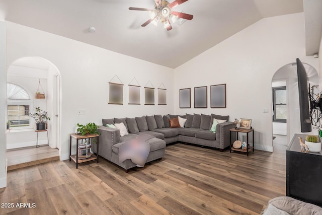 living room featuring ceiling fan, wood finished floors, and arched walkways