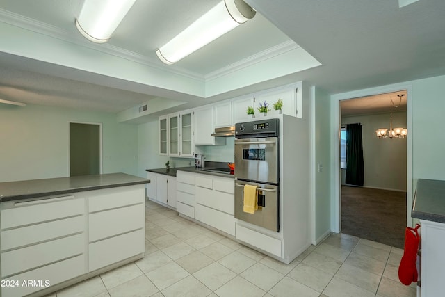 kitchen with white cabinets, black electric stovetop, ornamental molding, double oven, and a notable chandelier