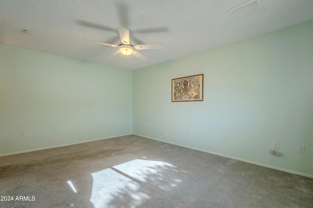 empty room with carpet, ceiling fan, and a textured ceiling