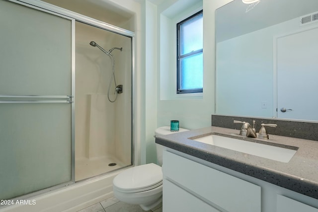 bathroom featuring tile patterned floors, vanity, an enclosed shower, and toilet