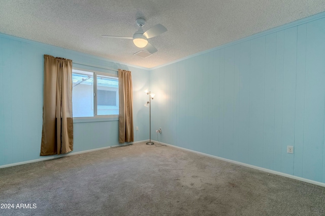 carpeted spare room featuring ceiling fan and a textured ceiling