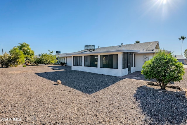 back of property with a sunroom and central air condition unit