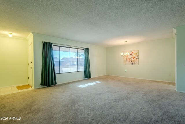 unfurnished room with a textured ceiling, crown molding, light carpet, and an inviting chandelier