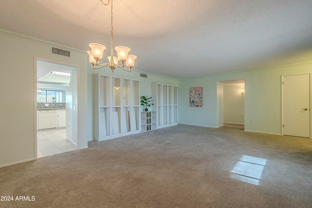 spare room with a textured ceiling, ornamental molding, light carpet, and an inviting chandelier