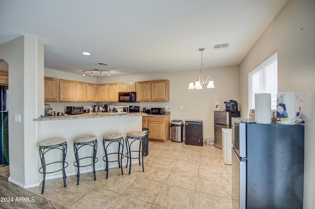 274 S 18th St, Coolidge, AZ 85128 - kitchen with a kitchen breakfast bar, stainless steel fridge, light brown cabinetry, a notable chandelier, and kitchen peninsula