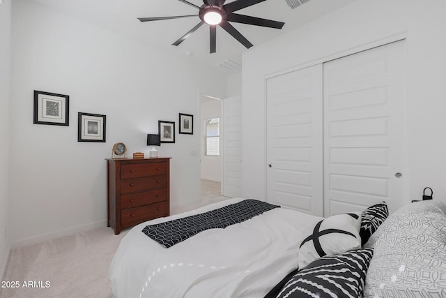 bedroom with light carpet, ceiling fan, and a closet