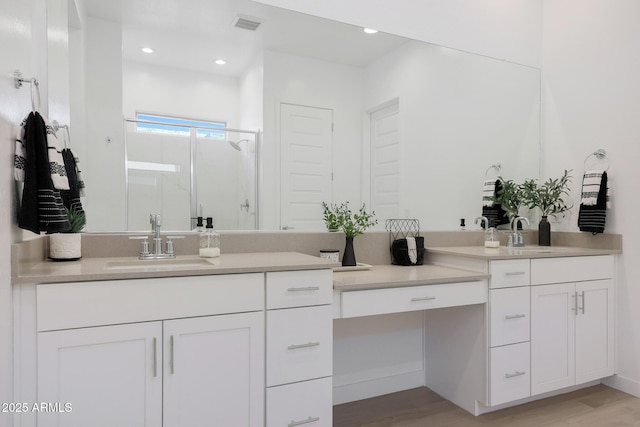 bathroom featuring vanity, hardwood / wood-style flooring, and a shower with shower door