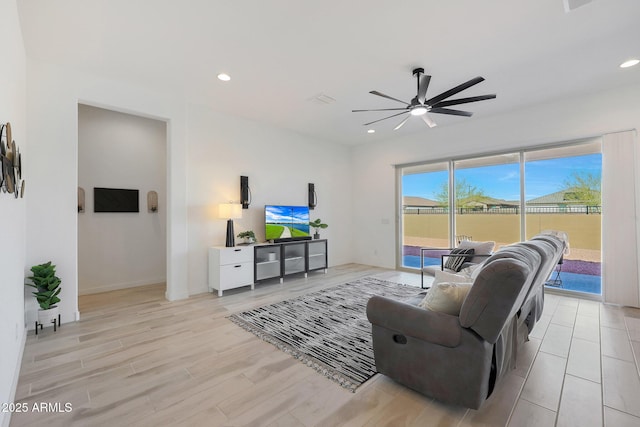 living room with light hardwood / wood-style flooring and ceiling fan