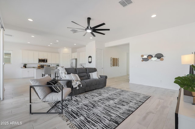 living room featuring ceiling fan and light wood-type flooring