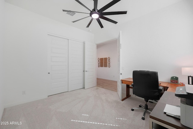 unfurnished office featuring ceiling fan and light carpet