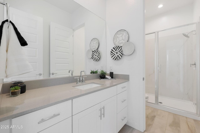 bathroom with vanity, toilet, and a shower with shower door