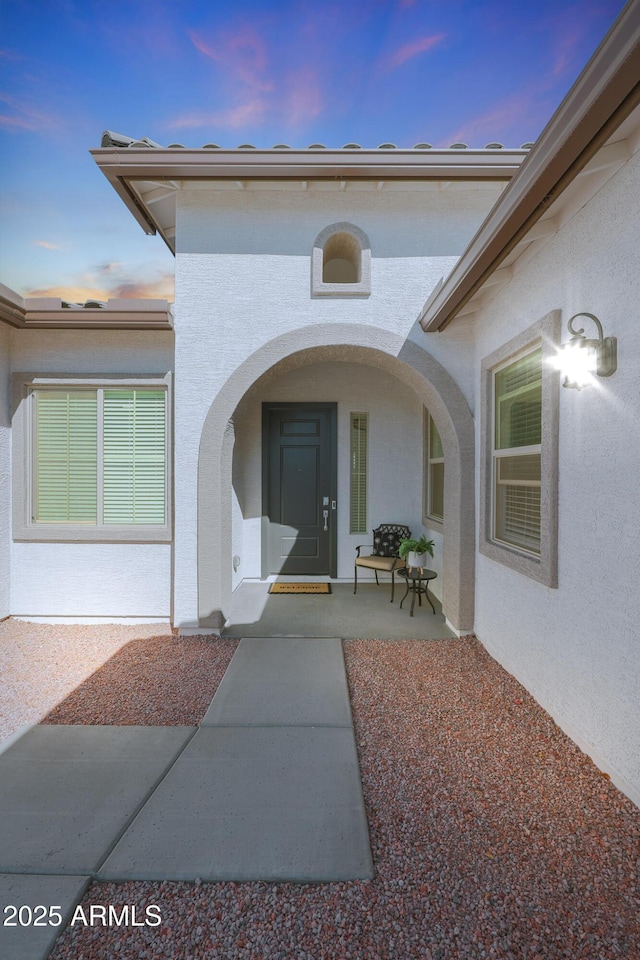 exterior entry at dusk with a patio