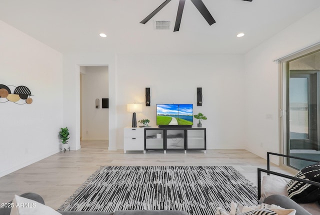 living room featuring ceiling fan and light hardwood / wood-style flooring