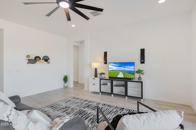 living room featuring ceiling fan and light hardwood / wood-style floors