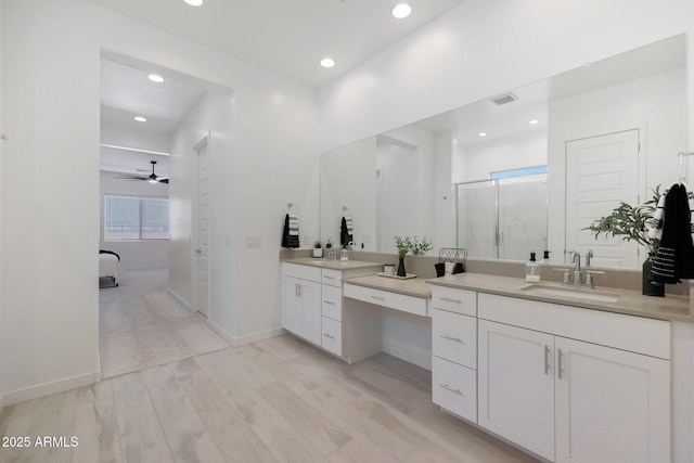 bathroom featuring vanity, a shower with shower door, and wood-type flooring