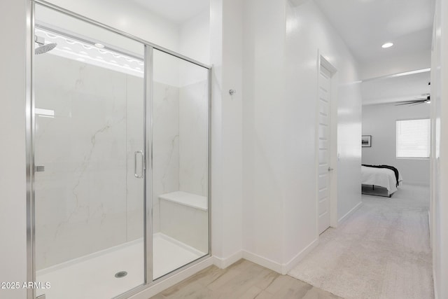 bathroom featuring ceiling fan and a shower with door