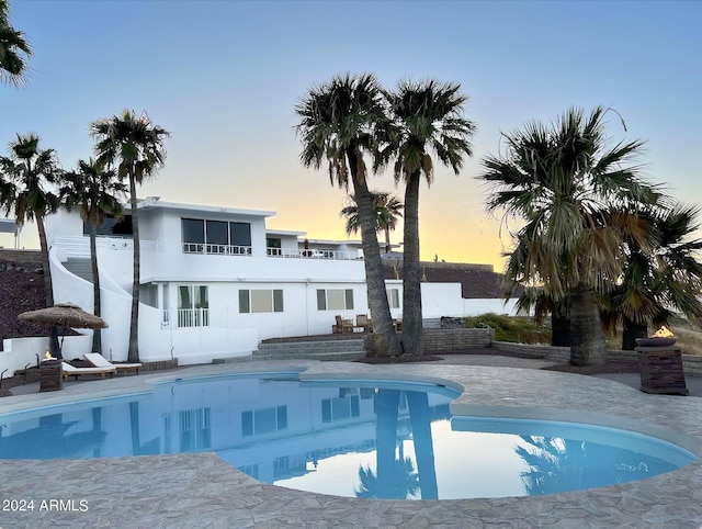 pool at dusk with a patio