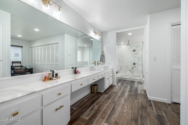 bathroom featuring hardwood / wood-style floors, vanity, and walk in shower