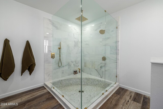 bathroom with hardwood / wood-style floors and a shower with shower door