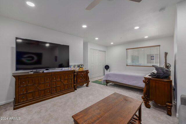 bedroom featuring ceiling fan, a closet, and light colored carpet