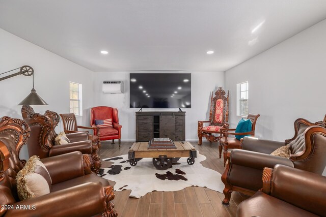 living room featuring an AC wall unit and light hardwood / wood-style floors