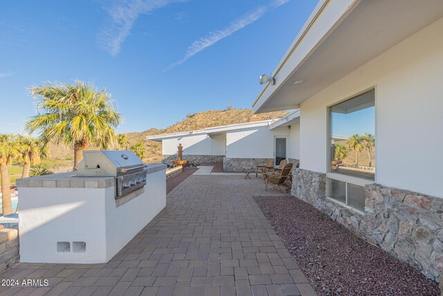 view of patio / terrace with a mountain view, exterior kitchen, and grilling area