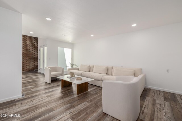 living room featuring hardwood / wood-style floors and brick wall